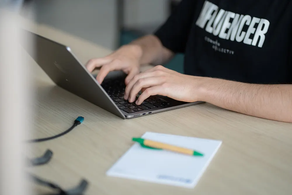 Handen op een laptop met een website