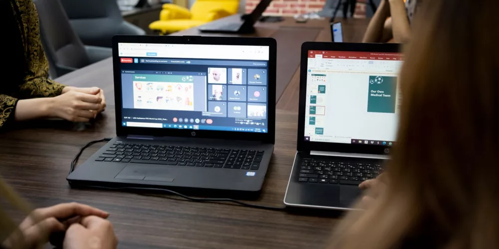 Team discusses projects during a virtual and in-person meeting in a Dubai office.